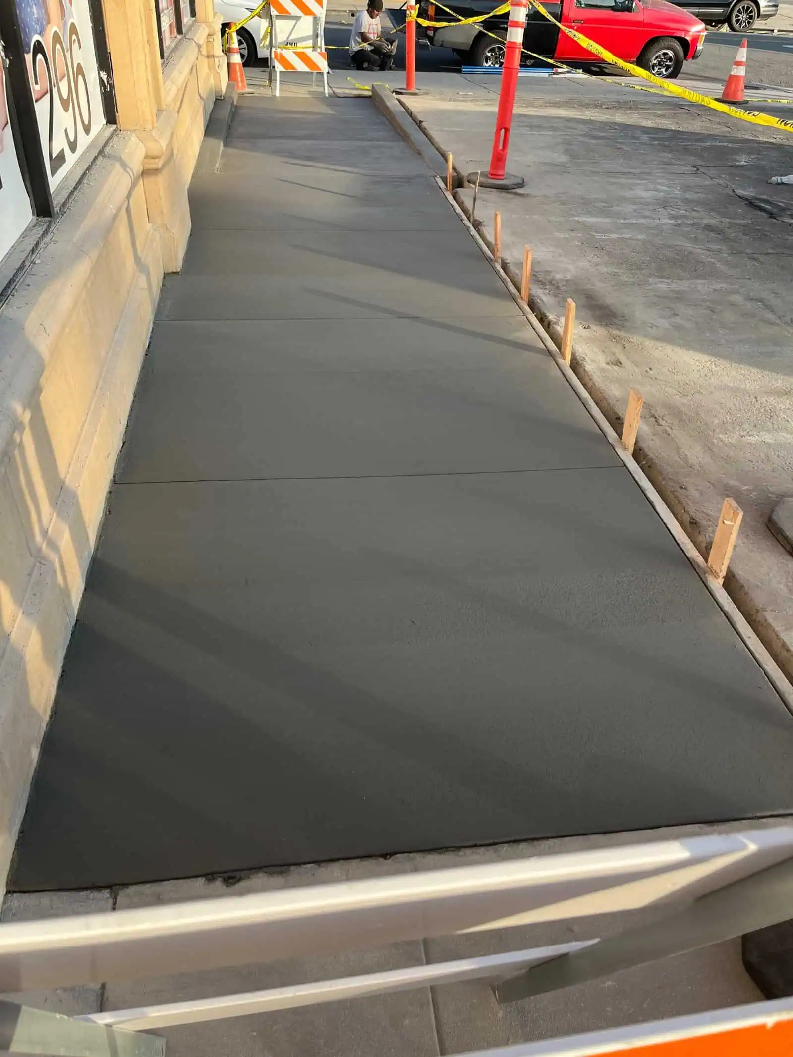 Freshly poured concrete sidewalk with wooden forms in place.