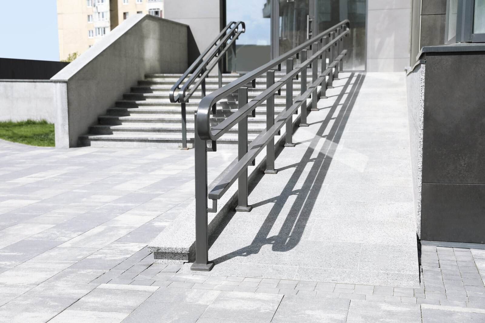Accessible ramp with handrails outside a modern commercial building.