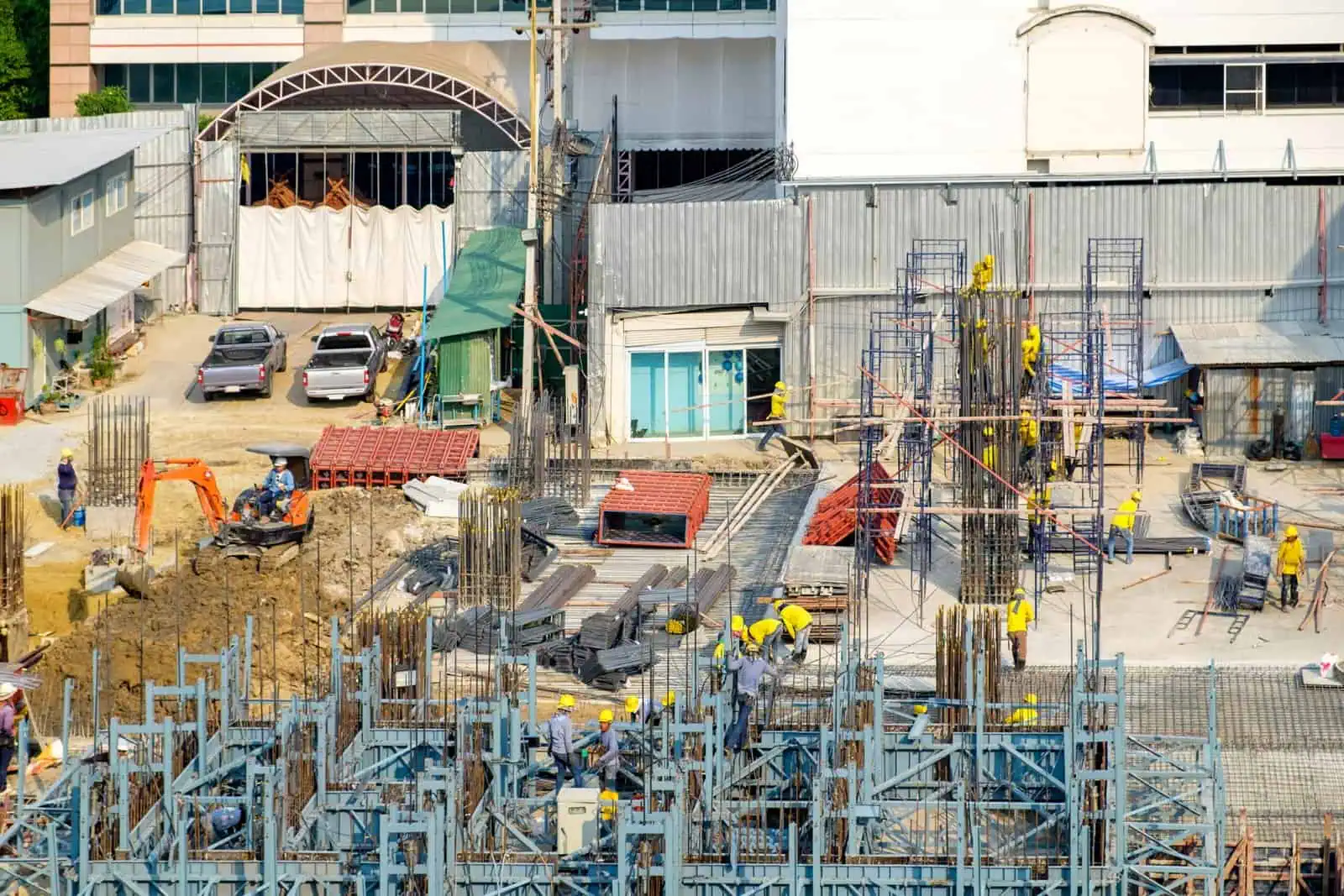 Construction workers and equipment at a concrete project site in progress.